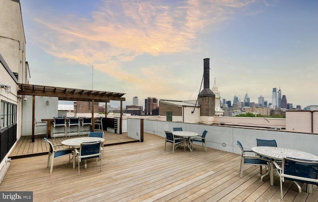 deck at dusk featuring an outdoor bar