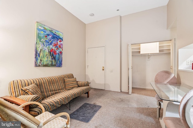 carpeted living room with a towering ceiling