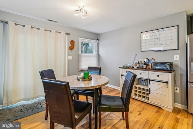 dining space with light hardwood / wood-style floors