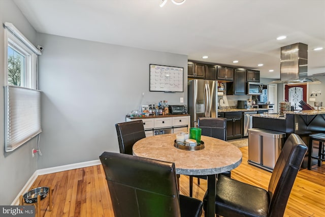 dining space with sink and light hardwood / wood-style floors