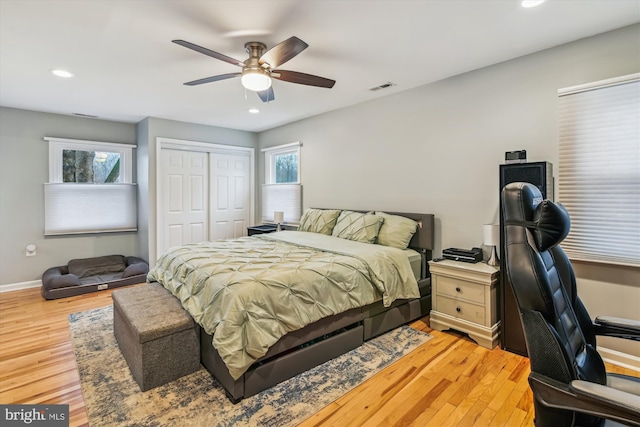 bedroom with ceiling fan, light hardwood / wood-style floors, and a closet