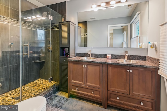 bathroom with vanity, toilet, and an enclosed shower