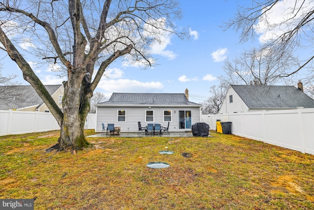 back of house with a patio and a lawn