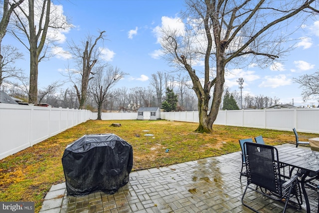 view of patio with area for grilling and a storage unit