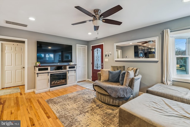 living room featuring ceiling fan and light hardwood / wood-style flooring