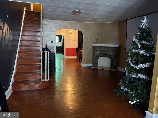 living room with a brick fireplace and hardwood / wood-style flooring