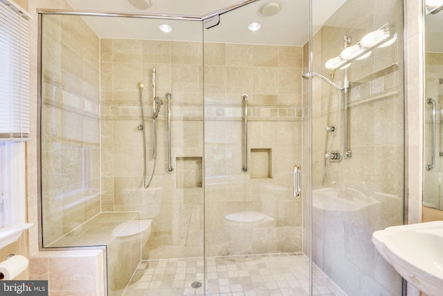 bathroom featuring toilet, an enclosed shower, and sink