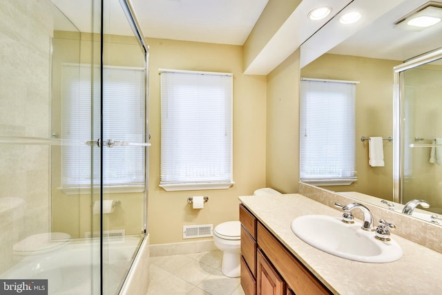 bathroom featuring vanity, toilet, a shower with shower door, and tile patterned flooring