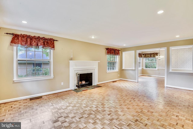 unfurnished living room with light parquet flooring, a brick fireplace, and ornamental molding