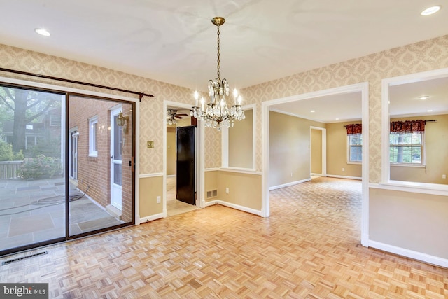 spare room with an inviting chandelier and light parquet flooring