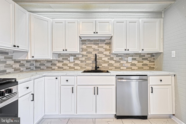 kitchen featuring appliances with stainless steel finishes, light stone countertops, sink, and white cabinets