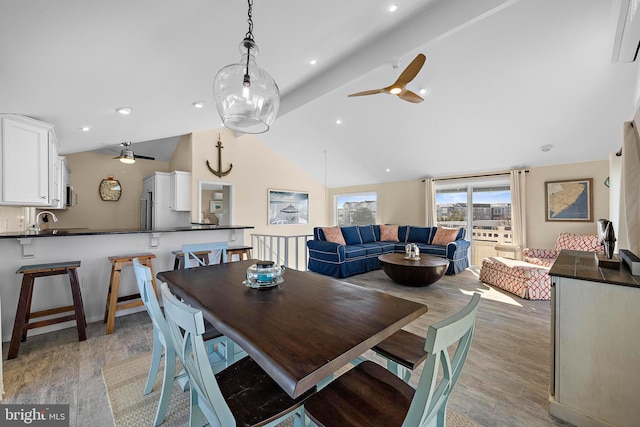 dining room featuring lofted ceiling, sink, ceiling fan, and light wood-type flooring