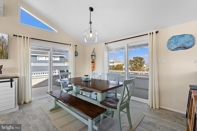 dining area with vaulted ceiling and light wood-type flooring