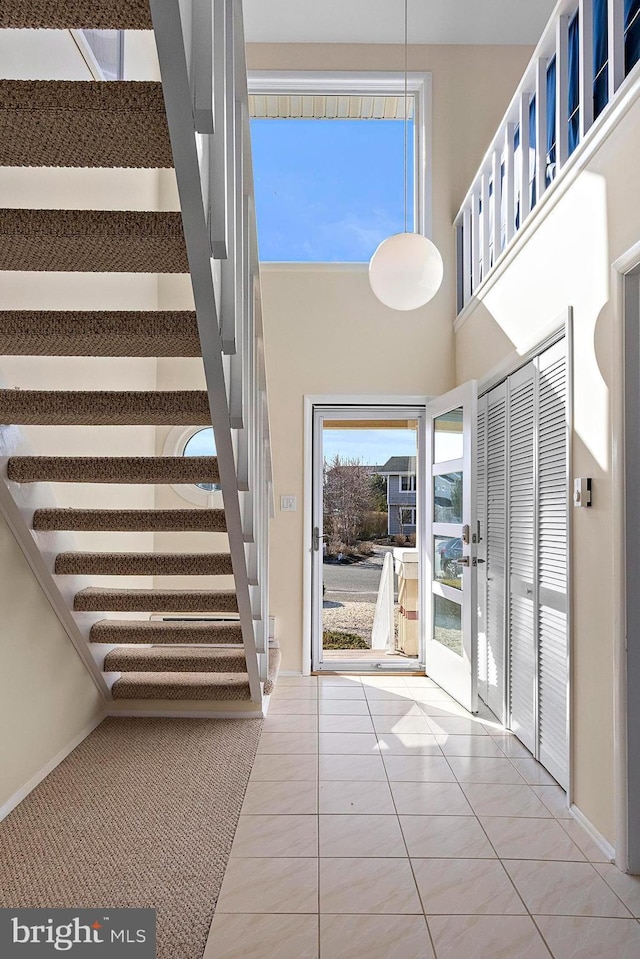 foyer entrance with a towering ceiling and tile patterned floors