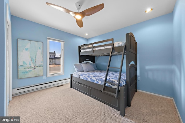 bedroom with ceiling fan, carpet, and a baseboard heating unit