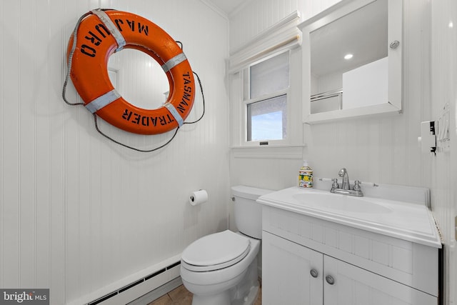 bathroom with a baseboard radiator, vanity, and toilet