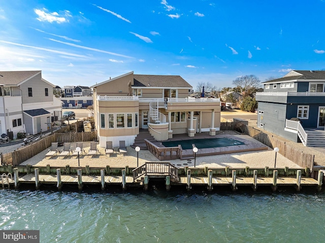 rear view of house with a water view and a patio area