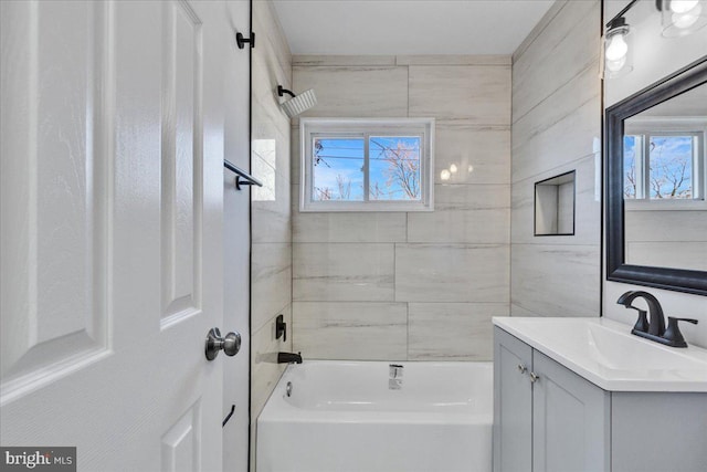 bathroom featuring tiled shower / bath and vanity