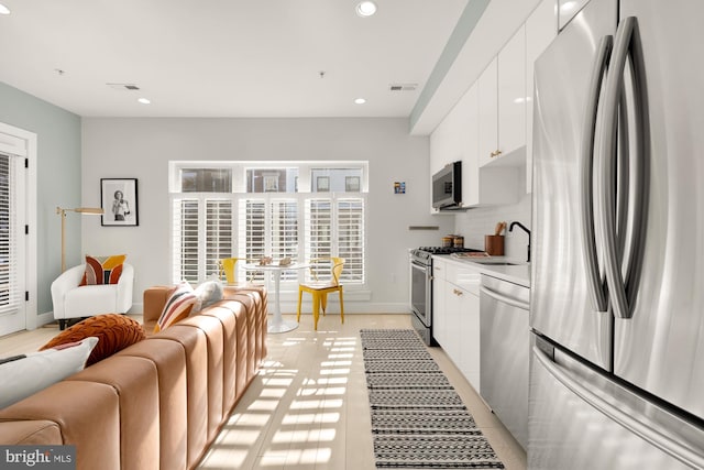 kitchen with white cabinetry, appliances with stainless steel finishes, sink, and decorative backsplash