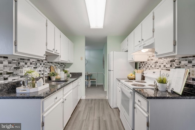 kitchen with sink, white cabinetry, light wood-type flooring, white appliances, and dark stone counters