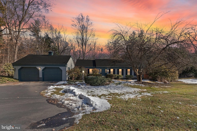 view of front of property featuring a garage and a lawn