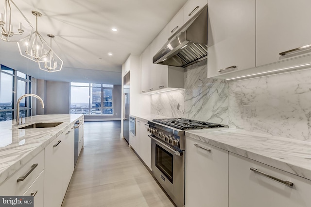 kitchen featuring white cabinetry, appliances with stainless steel finishes, decorative light fixtures, and sink