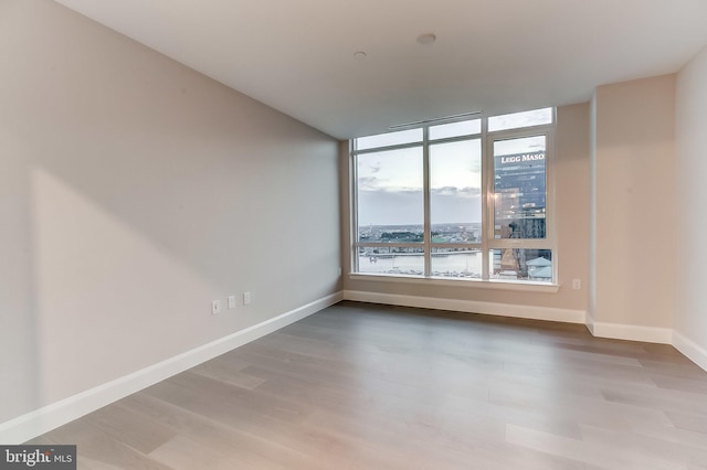 empty room featuring a water view and hardwood / wood-style floors