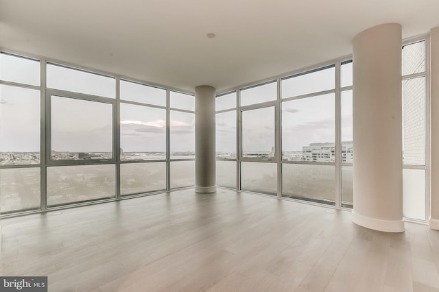 unfurnished sunroom featuring ornate columns