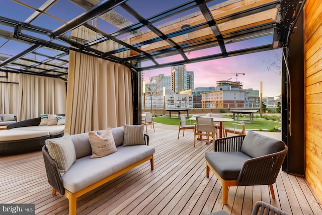 deck at dusk with a pergola and an outdoor hangout area