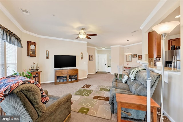 carpeted living room with crown molding and ceiling fan