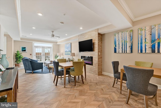 dining room with a tiled fireplace, crown molding, french doors, and light parquet floors