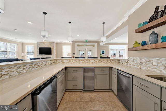 kitchen with backsplash, stainless steel dishwasher, hanging light fixtures, and gray cabinetry