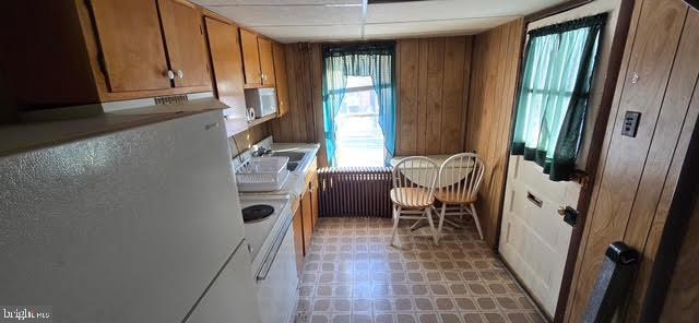 kitchen with sink, radiator heating unit, and white fridge