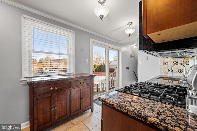 kitchen featuring sink, crown molding, light tile patterned floors, dark stone countertops, and backsplash