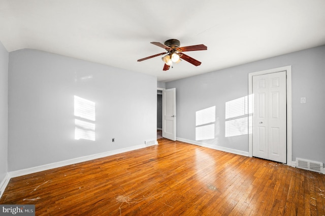 spare room featuring wood-type flooring, vaulted ceiling, and ceiling fan