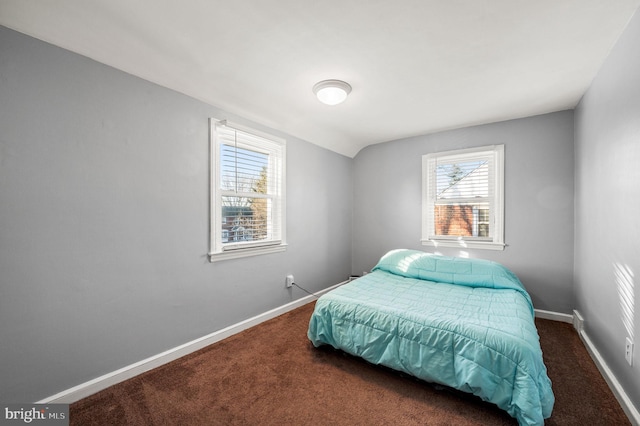 bedroom with vaulted ceiling and dark colored carpet