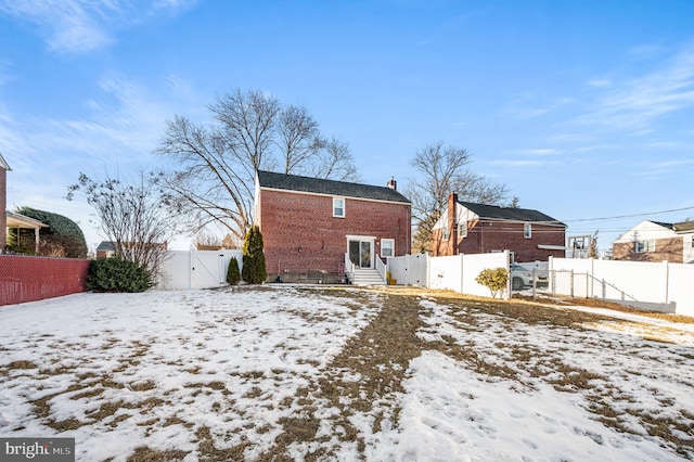 view of snow covered rear of property