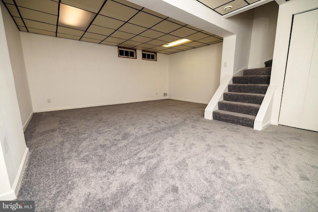 basement featuring carpet flooring and a paneled ceiling