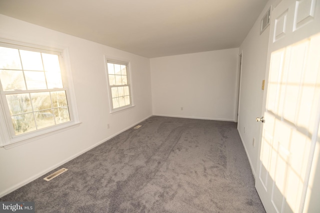 unfurnished room featuring dark colored carpet