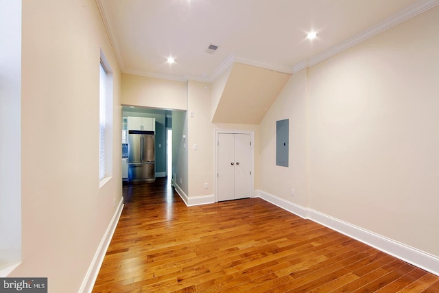 interior space featuring visible vents, baseboards, ornamental molding, electric panel, and wood finished floors