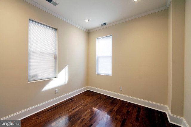 spare room with dark wood-type flooring, baseboards, visible vents, and ornamental molding