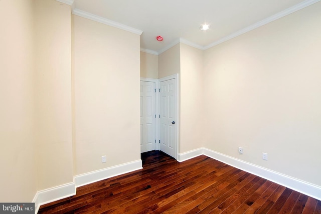 spare room with baseboards, dark wood-style floors, and ornamental molding