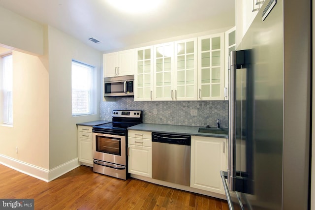 kitchen featuring backsplash, visible vents, appliances with stainless steel finishes, and a sink