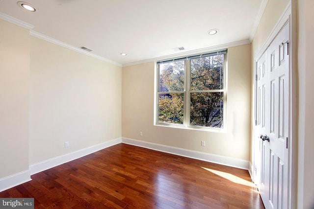 unfurnished bedroom with visible vents, wood finished floors, baseboards, and ornamental molding