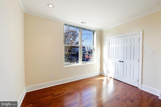 unfurnished bedroom featuring baseboards, wood finished floors, and ornamental molding