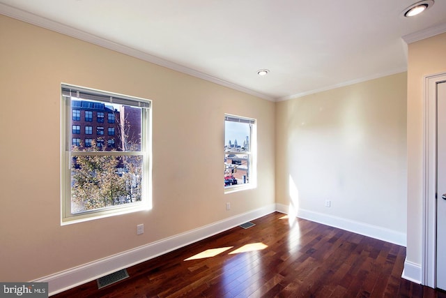 unfurnished room with crown molding, hardwood / wood-style flooring, baseboards, and visible vents