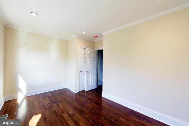 empty room with ornamental molding, baseboards, and hardwood / wood-style floors