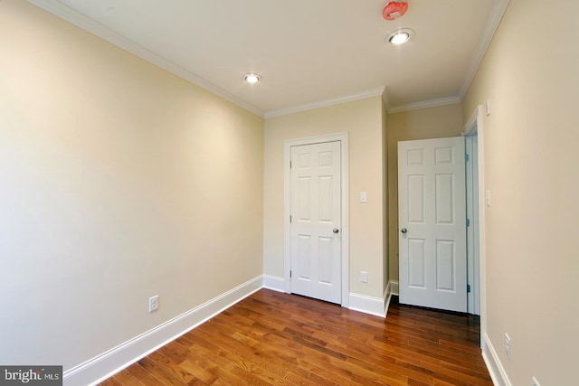 unfurnished bedroom featuring ornamental molding, baseboards, and wood finished floors