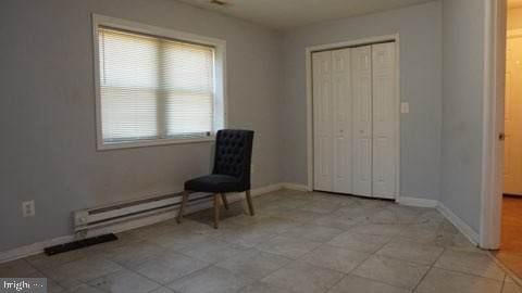 unfurnished room with a baseboard heating unit