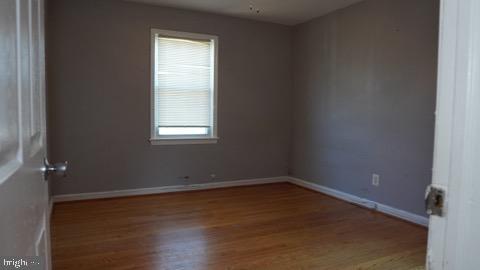 spare room featuring wood-type flooring